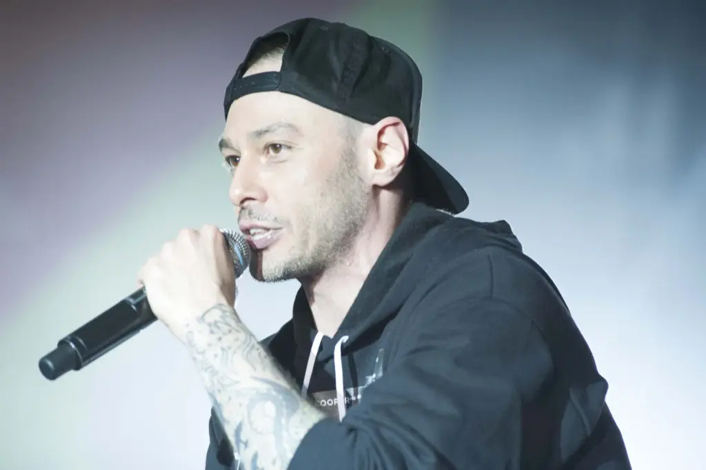 Fabri Fibra al microfono durante un concerto a Milano