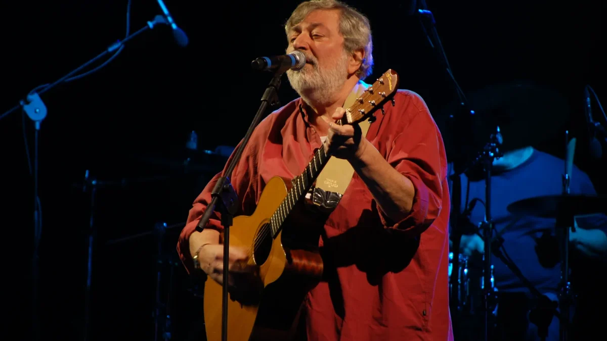 Francesco Guccini canta e suona la chitarra durante un concerto