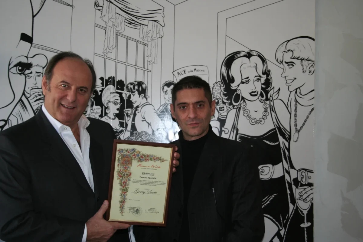 Gerry Scotti in abito scuro mentre riceve un premio durante un incontro pubblico