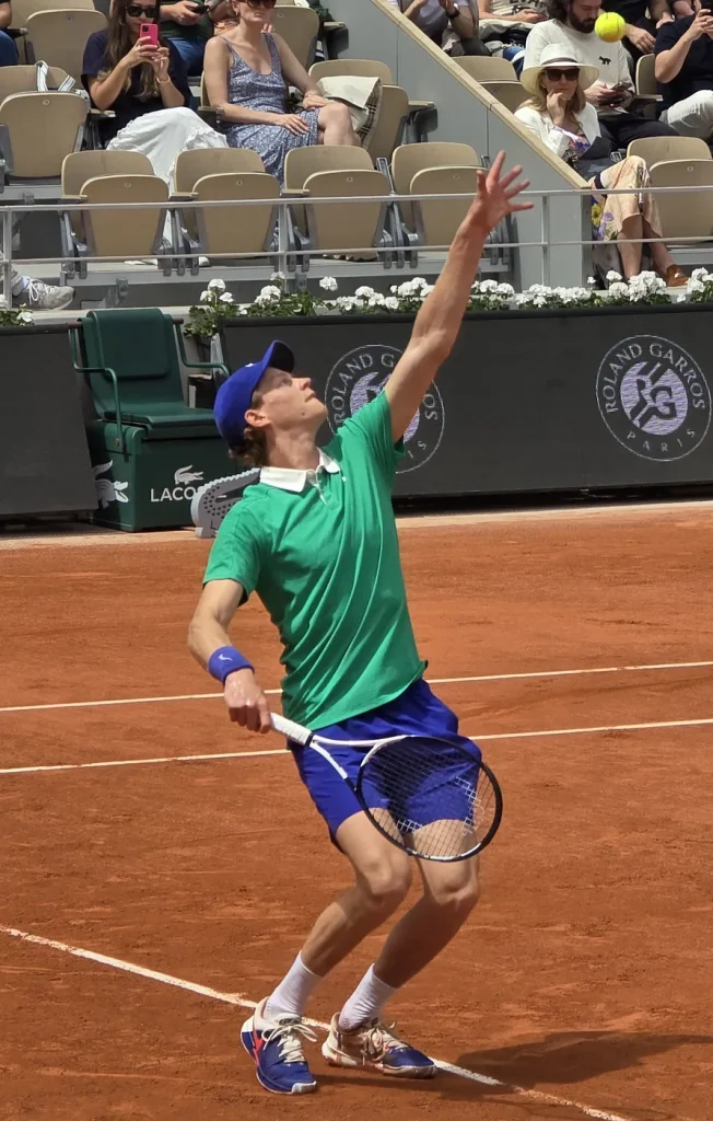 Jannik Sinner al servizio durante una partita su terra rossa